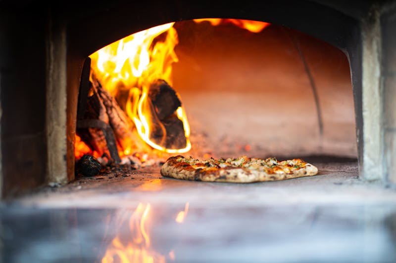 Wood-fired oven at Pizza Ranch — intense heat creating perfect crusts